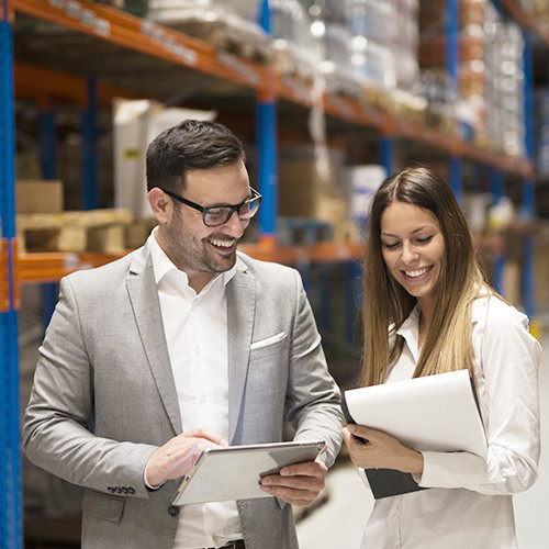 Zwei Logistikmitarbeiter vergleichen Unterlagen
